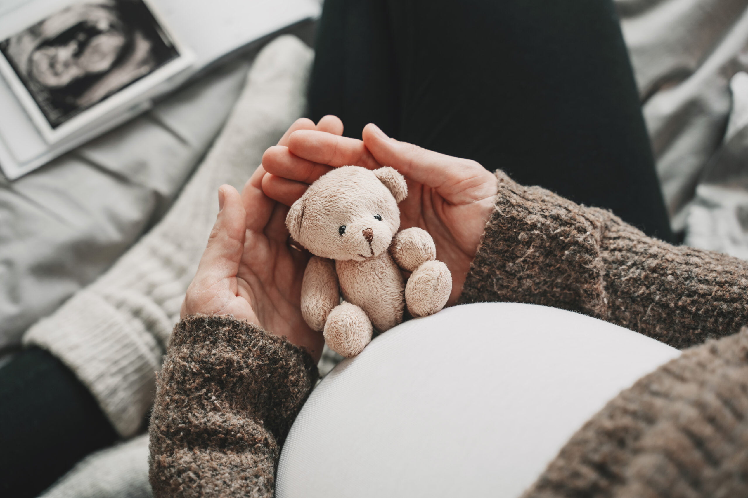 Woman pregnant belly with little teddy toy bear. Concept image with symbol of many meanings for expectant mother during pregnancy and her unborn baby. Woman pregnant belly with little teddy toy bear. Concept image with symbol of many meanings for expectant mother during pregnancy and her unborn baby.